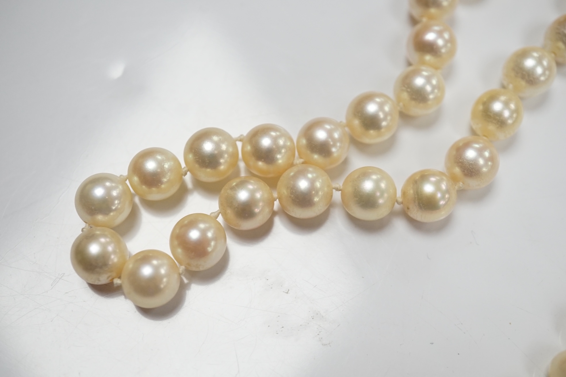 Two modern single strand cultured pearl necklaces, one with cultured pearl and gem set 18ct gold clasp, 48cm, the other with cultured pearl cluster set 9ct gold clasp, 54cm. Condition - fair to good.